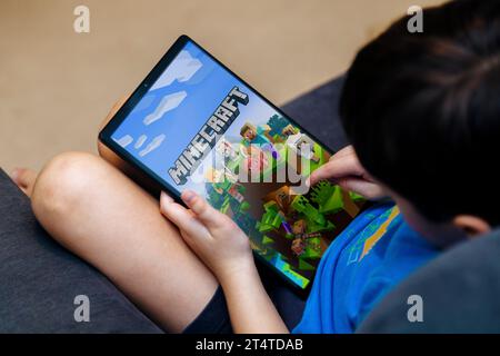Kleiner Junge, der Minecraft-Spiel auf einem Tablet spielt. Minecraft ist ein sehr beliebtes Spiel bei Kindern und Jugendlichen. Rosario, Argentinien - 20. Oktober 2023. Stockfoto