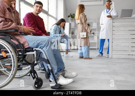 Junger Mann im Rollstuhl, der im Krankenhaus darauf wartet, dass er an der Reihe ist Stockfoto