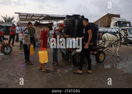 Gaza. November 2023. Am 1. November 2023 holen Palästinenser Wasser in einem Lager des Hilfswerks der Vereinten Nationen für Palästinaflüchtlinge im Nahen Osten (UNRWA) in Khan Younis im südlichen Gazastreifen. Die jüngsten Zahlen des UNRWA, das rund 13.000 Mitarbeiter im Gazastreifen beschäftigt, haben das Ausmaß der humanitären Krise stark erleichtert. Die Agentur sagte, dass 670.000 Binnenvertriebene in 150 UNRWA-Anlagen Unterschlupf finden. Quelle: Rizek Abdeljawad/Xinhua/Alamy Live News Stockfoto