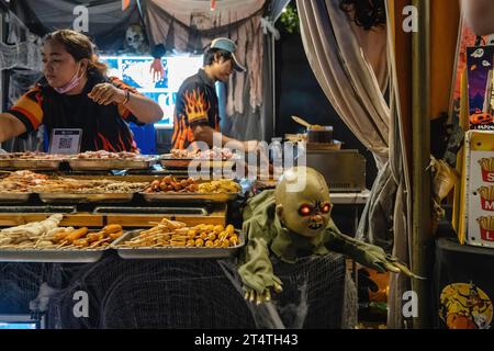 Bangkok, Thailand. 31. Oktober 2023. Ein Stand mit thailändischen Snacks wird während des Happy Halloween Festivals 2023 auf den Jodd Fairs DanNeramit in Bangkok gezeigt. Der berühmteste Nachtmarkt in Bangkok, Jodd Fairs, eröffnete vor kurzem eine neue Filiale im DanNeramit, einem formellen Freizeitpark mit einem Märchenschloss, das auf einer Fläche von 52800 Quadratmetern mit verschiedenen Ständen wie Kleidung und Accessoires, Vintage-Artikeln, Craft-Bieren, Souvenirs, thailändischen und internationalen Speisen umfasst. (Foto: Nathalie Jamois/SOPA Images/SIPA USA) Credit: SIPA USA/Alamy Live News Stockfoto