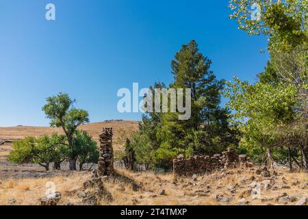 Die Ruinen eines Steingebäudes, das auf einem Feld in Hornitos, Kalifornien, liegt. Stockfoto