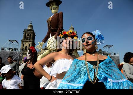 Mexiko-Stadt, Mexiko. November 2023. Mädchen, die sich für die Dia de Muertos Feiern verkleidet haben, nehmen an der Mega Monumental Opferung des Todestages im Zocalo von Mexiko-Stadt Teil. Am 1. November 2023 in Mexiko-Stadt. (Kreditbild: © Carlos Tischler/OKULARBOGEN via ZUMA Press Wire) NUR REDAKTIONELLE VERWENDUNG! Nicht für kommerzielle ZWECKE! Stockfoto