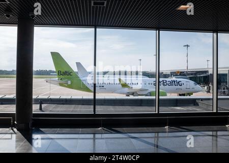 Bild eines Airbus A220 Air Baltic, der auf den Abflug am Flughafen Riga (Rigas Lidosta) wartet. EasyJet Airline Company Limited ist eine britische billigfluggesellschaft Stockfoto