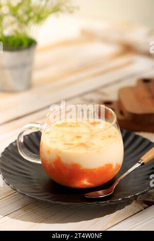 Koreanischer Mangomilzjoghurt auf Holztisch, auf schwarzer Platte Stockfoto
