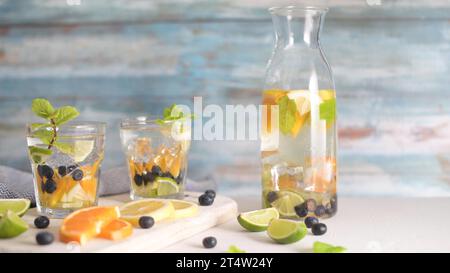 Sommerliche gesunde Cocktails aus Zitruswasser, Limonaden oder Mojitos, mit Limone Zitronenorange Blaubeeren und Minze, Diät Entgiftungsgetränke, in Gläsern Stockfoto