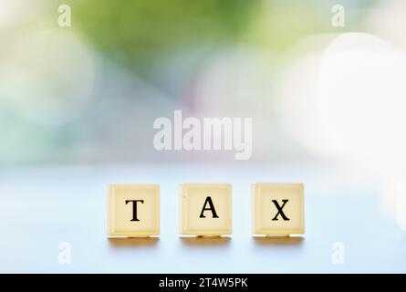 Steuer, Wort oder Nachricht auf Holzblöcken oder Briefe, die auf Finanzdaten, Berichten oder Geldverwaltung auf einem Bokeh-Hintergrund schreiben. Buchhaltungsmodell Stockfoto