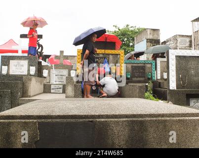 Caloocan, Philippinen. November 2023. Menschen, die auf dem Friedhof trotz starker Regengüsse gesehen wurden. Menschen strömen zum Friedhof Sangandaan, um den UNDAS oder Allerheiligen in Caloocan City zu beobachten, trotz heftiger Regenfälle, um ihre verstorbenen Angehörigen zu besuchen. Die Philippine National Police (PNP) Caloocan wurde außerhalb des Friedhofs eingesetzt, um die Ordnung und Sicherheit der Öffentlichkeit zu gewährleisten. (Foto von Josefiel Rivera/SOPA Images/SIPA USA) Credit: SIPA USA/Alamy Live News Stockfoto