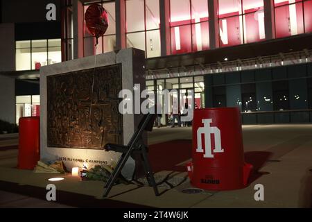 Bloomington, USA. November 2023. BLOOMINGTON, INDIANA – 1. NOVEMBER: Blumen und ein Stuhl befinden sich an der Basis der NCAA-Basketball-Meisterschaftstafel 1976 vor der Simon Skjodt Assembly Hall, wo Bob Knight, der verstorben ist, am 1. November 2023 in Bloomington, Indiana trainierte. Knight trainierte die Basketballmannschaft der Männer in der Assembly Hall und gewann mit seinem Team die NCAA Basketball-Meisterschaften 1976, 1981 und 1987. (Filmmaterial von Jeremy Hogan/Alamy Live News Stockfoto