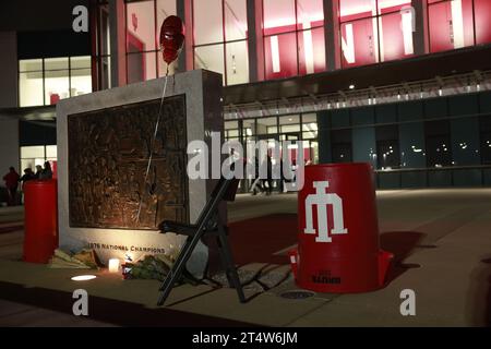 Bloomington, USA. November 2023. BLOOMINGTON, INDIANA – 1. NOVEMBER: Blumen und ein Stuhl befinden sich an der Basis der NCAA-Basketball-Meisterschaftstafel 1976 vor der Simon Skjodt Assembly Hall, wo Bob Knight, der verstorben ist, am 1. November 2023 in Bloomington, Indiana trainierte. Knight trainierte die Basketballmannschaft der Männer in der Assembly Hall und gewann mit seinem Team die NCAA Basketball-Meisterschaften 1976, 1981 und 1987. (Filmmaterial von Jeremy Hogan/Alamy Live News Stockfoto