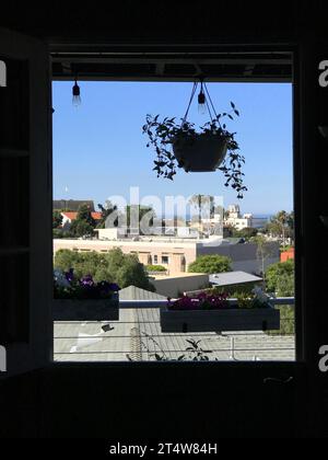 Blick auf eine Wohnstraße mit Häusern durch ein Fenster Stockfoto