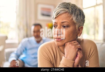 Scheidung, Senior Frau und Streit oder traurig in der Ehe im Wohnzimmer mit Partner oder wütend zu Hause. Problematische, verärgerte und weibliche Person mit Konflikten Stockfoto