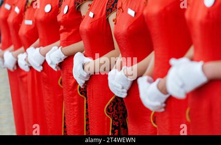 Die chinesische Kellnerin trug rote Cheongsam und weiße Handschuhe Stockfoto