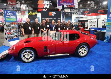 Las Vegas, Usa. November 2023. Der weltbekannte Automobildesigner Peter Brock (Mitte) posiert für ein Foto mit seinem persönlichen Sportwagen Shelby Cobra, während er während der SEMA Show 2023 im Las Vegas Convention Center in Las Vegas, Nevada, am Mittwoch, 1. November 2023 von Ausstellern von Atech Motorsports umgeben ist. Foto: James Atoa/UPI Credit: UPI/Alamy Live News Stockfoto