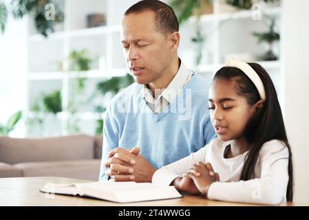 Familie, Kinder und Gebet mit Bibelbüchern zur Unterstützung, zum Glauben oder zum christlichen Gottesdienst zu Hause. Vater, Mädchen Kind oder Gebet der Religion, spirituelles Vertrauen oder Stockfoto