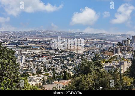 Haifa, Israel - 22. Oktober 2023: Panorama eines Industrie- und Wohngebietes vor blauem Himmel mit Wolken. Stockfoto