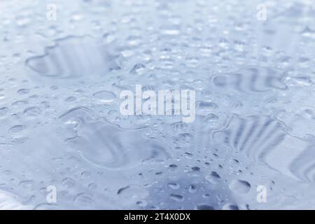 Wassertropfen sind auf glänzender Stahlplatte, Makrofoto, Hintergrundstruktur Stockfoto