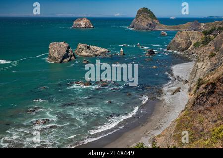 Seestapel, Sisters Rocks Formation in der Ferne, Seehunde sichtbar im Wasser, in der Nähe von Port Orford, Oregon, USA Stockfoto