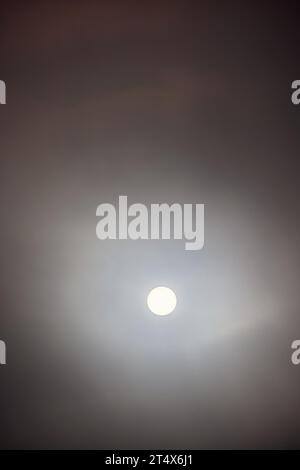 Die Sonne scheint durch die dunklen Wolken am Himmel Stockfoto