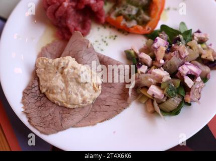 Eine köstliche Vorspeise aus Piedmont. Steak Tartare, Carpaccio, gefüllte Paprika und Salat Stockfoto
