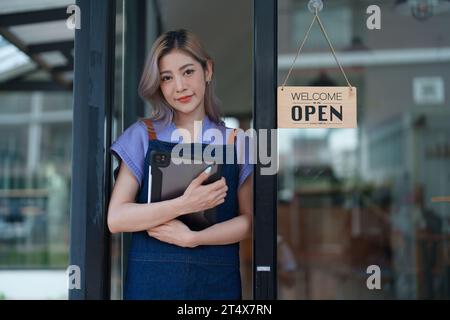 Erfolgreiche Inhaber eines kleinen Unternehmens kmu-Schönheitssalon mit Tablet im Café-Restaurant, asiatische Bräunungsfrau Barista-Café-Besitzer, Unternehmer Stockfoto