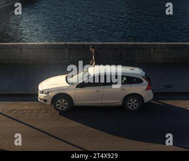 Die Ruhe eines Volvo-Autos, das bei Sonnenuntergang auf einer leeren Straße im Herzen Stockholms steht. Stockfoto