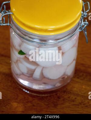 Eingelegte Daikon Radieschen in einem Glasgefäß mit grünem Chili für den Geschmack Stockfoto