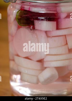 Eingelegte Daikon-Radieschen in einem Glas mit einer Scheibe Rote Bete Stockfoto