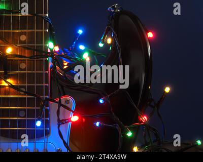 Alte alte alte alte elektrische Gitarre mit Weihnachtsbeleuchtung auf einem rustikalen Holzhintergrund Stockfoto