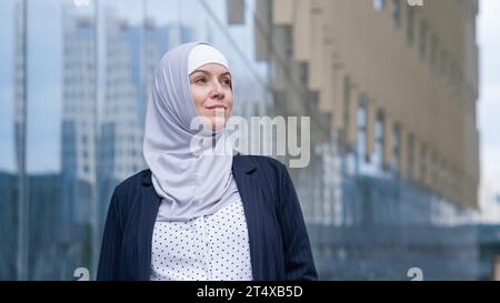 Porträt einer lächelnden Geschäftsfrau im Hijab und Anzug draußen. Stockfoto