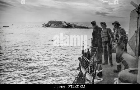 Am 17. Juni 1940 wurde der Cunard-White-Star-Linienschiff Lancastria von deutschen Tauchbombern angegriffen, während britische Truppen aus Dünkirchen evakuiert wurden. Evakuierte, die aus Sicherheitsgründen vor ihrem Untergang schwimmen, können von einem der Rettungsschiffe aus gesehen werden. Stockfoto