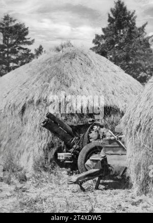 Eine große Anzahl australischer Truppen traf im Sommer 1940 in England ein. Dort, um das Land während der Angst vor einer deutschen Invasion zu schützen, verwenden australische Truppen Heuhaufen, um ihre Haubitzen zu tarnen. Stockfoto