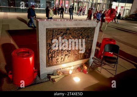 Bloomington, Usa. November 2023. Blumen und ein Stuhl befinden sich an der Basis der NCAA-Basketball-Meisterschaftstafel 1976 vor der Simon Skjodt Assembly Hall, wo Bob Knight, der verstorben ist, am 1. November 2023 in Bloomington, Indiana trainierte. Knight trainierte die Basketballmannschaft der Männer in der Assembly Hall und gewann mit seinem Team die NCAA Basketball-Meisterschaften 1976, 1981 und 1987. Quelle: SOPA Images Limited/Alamy Live News Stockfoto