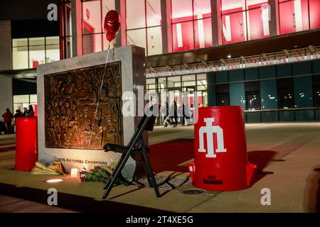 Bloomington, Usa. November 2023. Blumen und ein Stuhl befinden sich an der Basis der NCAA-Basketball-Meisterschaftstafel 1976 vor der Simon Skjodt Assembly Hall, wo Bob Knight, der verstorben ist, am 1. November 2023 in Bloomington, Indiana trainierte. Knight trainierte die Basketballmannschaft der Männer in der Assembly Hall und gewann mit seinem Team die NCAA Basketball-Meisterschaften 1976, 1981 und 1987. Quelle: SOPA Images Limited/Alamy Live News Stockfoto