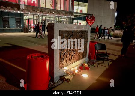 Bloomington, Usa. November 2023. Blumen und ein Stuhl befinden sich an der Basis der NCAA-Basketball-Meisterschaftstafel 1976 vor der Simon Skjodt Assembly Hall, wo Bob Knight, der verstorben ist, am 1. November 2023 in Bloomington, Indiana trainierte. Knight trainierte die Basketballmannschaft der Männer in der Assembly Hall und gewann mit seinem Team die NCAA Basketball-Meisterschaften 1976, 1981 und 1987. (Foto: Jeremy Hogan/SOPA Images/SIPA USA) Credit: SIPA USA/Alamy Live News Stockfoto