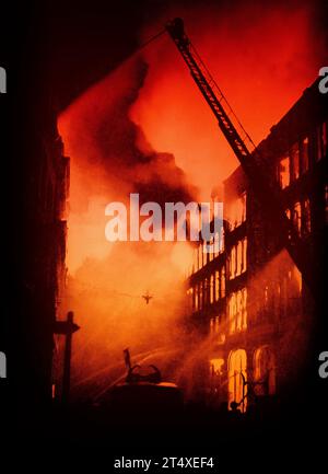 Kurz nach Mitternacht am 21. August 1940 wurden die ersten Bomben von der Luftwaffe auf London, England, abgeworfen, was einen Brand in einem großen Geschäftsgebäude verursachte. Ursprünglich in Schwarz und weiß, wurde die Farbe kürzlich hinzugefügt. Stockfoto