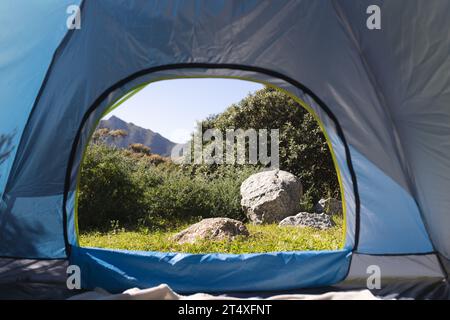 Blick auf Felsen in sonniger Landschaft und ferne Berge vom Zelt auf dem Campingplatz, Kopierraum Stockfoto