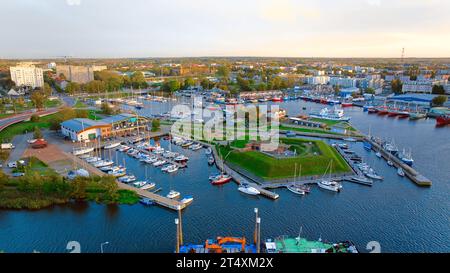 Ein atemberaubendes Drohnenfoto von Kołobrzeg Marina in Polen fängt eine malerische Szene ein. Die Aussicht zeigt eine Vielzahl von Yachten und Segelbooten. Stockfoto
