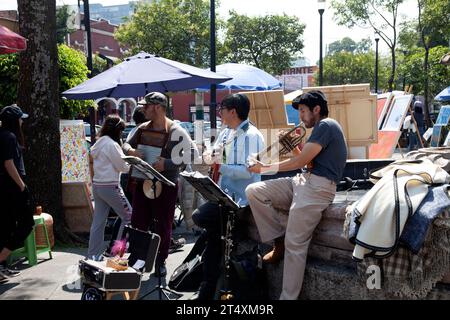 Musiker, die an Kunstsamstagen auf dem San Jacinto Square am Bazar Sabado in Mexiko-Stadt unterwegs sind Stockfoto