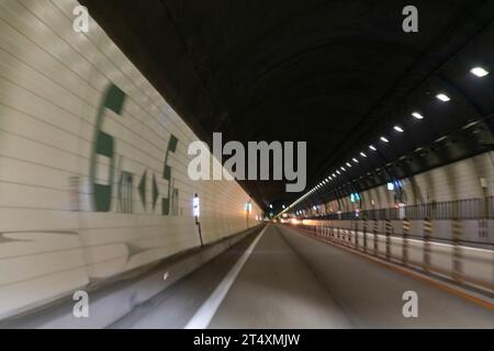 Hida, Gifu, Japan-20. April 2023; verschwommene Bewegungsperspektive des Fahrers im Hida-Tunnel auf der E41Tokai Hokuriku Expressway mit einer Länge von 11 km und Zahlen Stockfoto