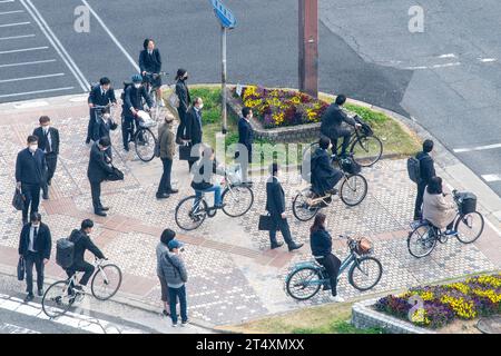 Hiroshima, Japan-10. April 2023; Hochwinkelansicht von Radfahrern und Fußgängern, meist in Geschäftskleidung, warten an der Ecke Rijo-Dori Avenu Stockfoto