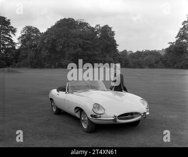 Frühes Schwarzweiß-Werbefoto des Jaguar E-TYPE S1, offener Zweisitzer, 3,8 L, mit Modell in schwarzem Kleid im Halesowen Golf Club am 21./8/1961 Stockfoto