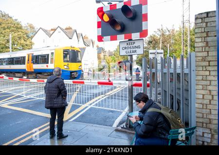 LONDON, 30. OKTOBER 2023: Bahnhof Acton Central und Straßenüberquerung. London Overland Zuglinie in West London Stockfoto