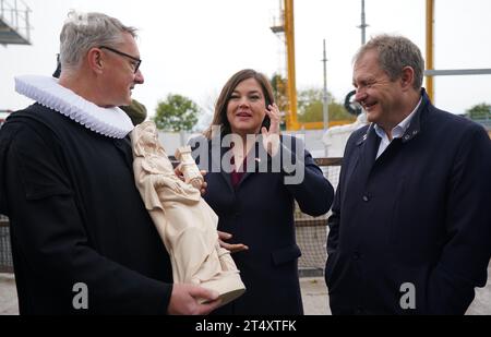 02. November 2023, Hamburg: Pfarrer Sieghard Wilm (l) von St. In der Pauli-Kirche befindet sich die Statue des Heiligen Barbara, Schutzpatronin der Bergleute, neben der Patenin Katharina Fegebank (Bündnis 90/die Grünen), zweite Bürgermeisterin und Senatorin für Wissenschaft, Forschung und Gleichstellung, und Jens Kerstan (Bündnis 90/die Grünen), Senator für Umwelt, Klima, Energie und Landwirtschaft in Hamburg, vor Bohrbeginn für Hamburgs neuen Fernwärmetunnel unter der Elbe. Nach Bergbaubräuchen wurde die Tunnelbohrmaschine für den neuen Fernwärmetunnel unter der Elbe in Hamburg „Hermine“ getauft Stockfoto