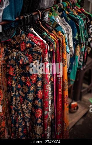 Eine lebendige Ausstellung von Kleidungsstücken auf einem Markt im Freien Stockfoto