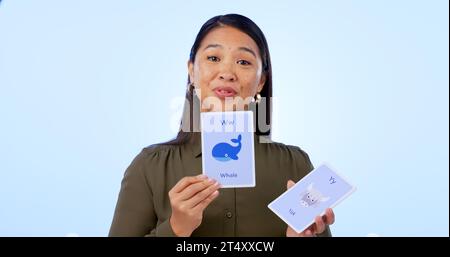 Asiatische Frau, Lehrerin und Flash-Karten für Unterricht, Bildung und isoliert auf Studio-Hintergrund. Portrait, Learning und Show für Entwicklung, elearning Stockfoto