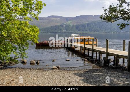 Menschen, die an Bord des Bootes gehen, starten am Holzsteg der High Brandelhow Bay Derwentwater im Sommer Lake District National Park Cumbria England Großbritannien Stockfoto