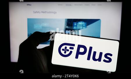 Person, die ein Mobiltelefon mit dem Logo des US-amerikanischen Autonome Speditionsunternehmens PlusAI Inc. Vor der Unternehmenswebseite hält. Schwerpunkt auf dem Display des Telefons. Stockfoto