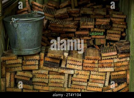 Ceredigion, Wales - 01. August 2023 Schneiden Sie alte Dielen für Brennholz und sammeln Sie sie im Holzlager, um sie für die Verwendung als Brennstoff zum Kochen vorzubereiten Stockfoto