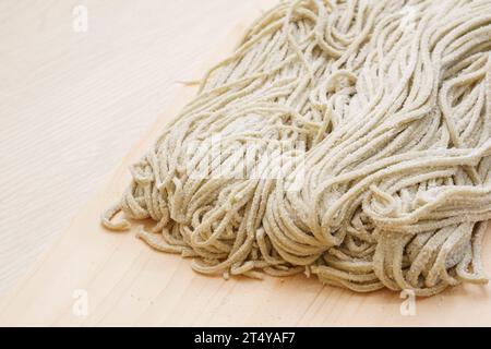 Hausgemachte rohe Buchweizen-Nudeln (Soba) auf hölzernem Hintergrund Stockfoto