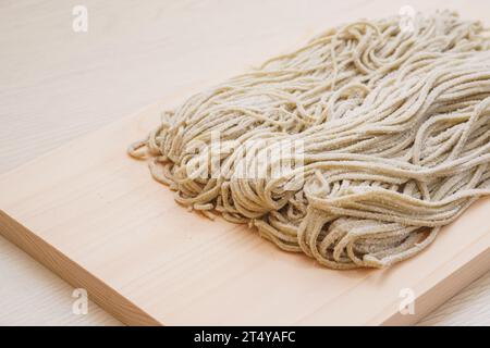 Hausgemachte rohe Buchweizennudeln (Soba) auf Holzbrett Stockfoto